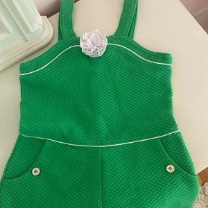 Adorable green quilted romper with white details on piping, buttons and flower